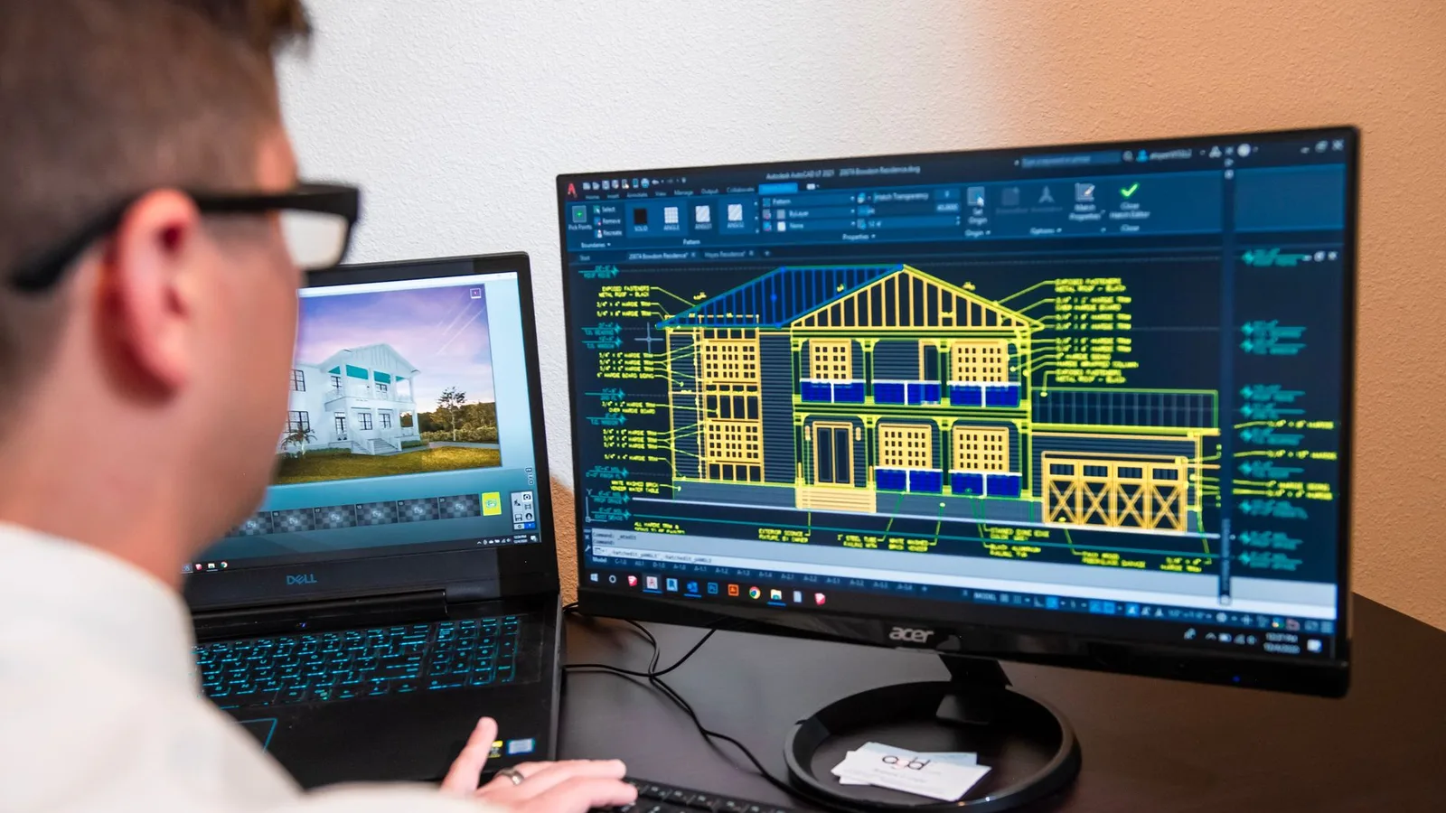 Architecte devant deux écrans affichant un plan de façade en CAO et un rendu 3D