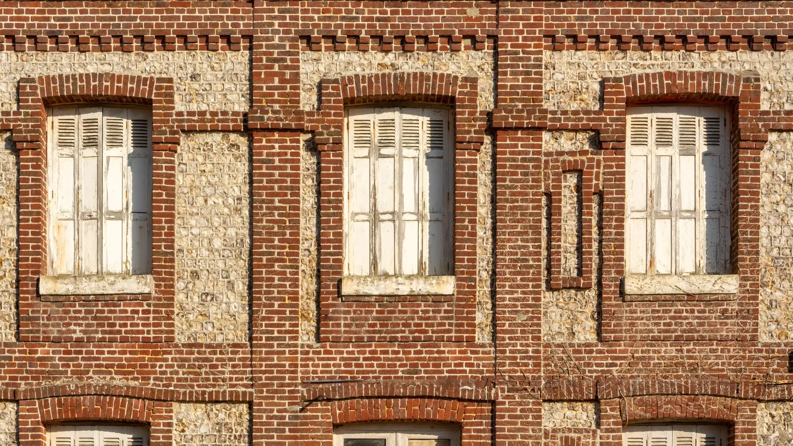 Façade ancienne en brique et silex avec encadrements de baies et modénatures